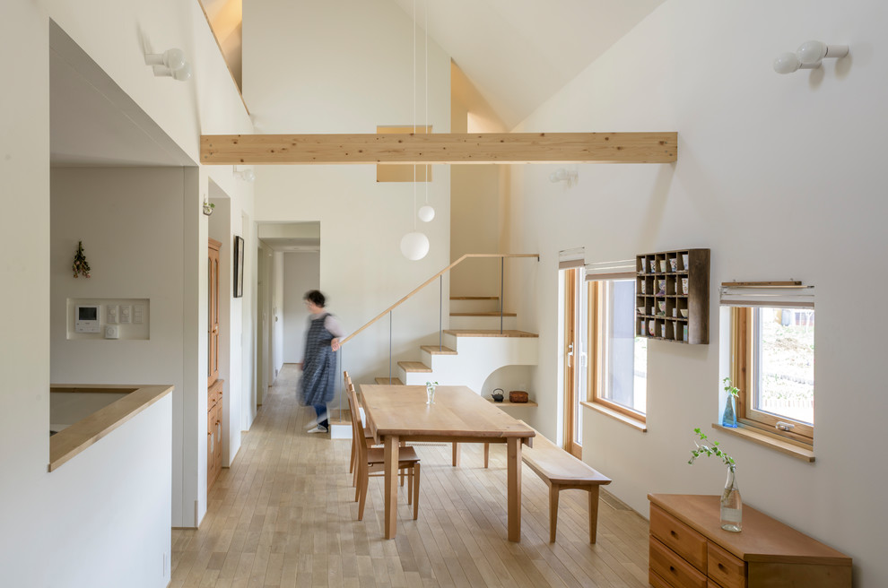 Bild på ett skandinaviskt vardagsrum, med vita väggar, ljust trägolv och brunt golv
