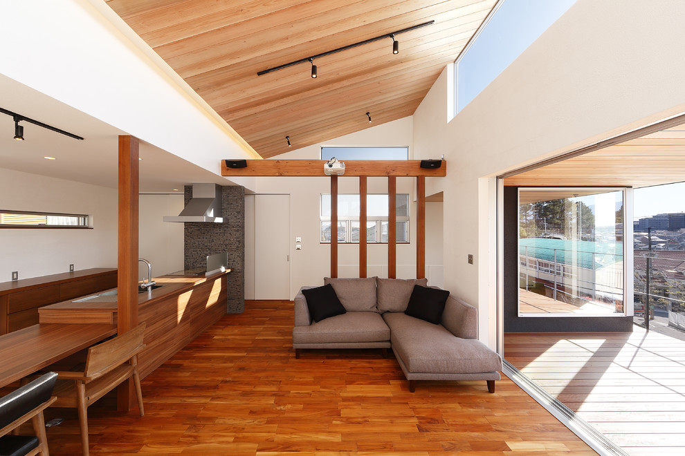 Свежая идея для дизайна: открытая гостиная комната в современном стиле с белыми стенами, паркетным полом среднего тона и коричневым полом - отличное фото интерьера