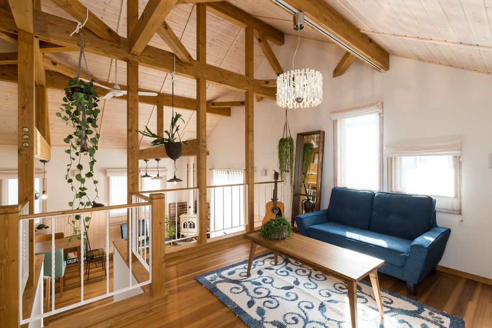 Ispirazione per un soggiorno stile marinaro con pareti bianche, pavimento in legno massello medio e pavimento marrone