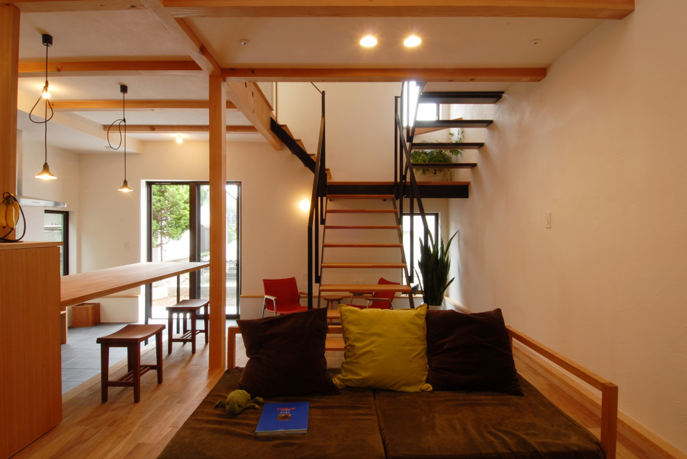 Inspiration pour un salon design ouvert avec un bar de salon, un mur beige, un sol en bois brun et aucune cheminée.