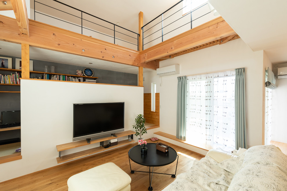 Foto di un soggiorno minimalista aperto con pareti bianche, pavimento in legno massello medio, nessun camino e pavimento beige