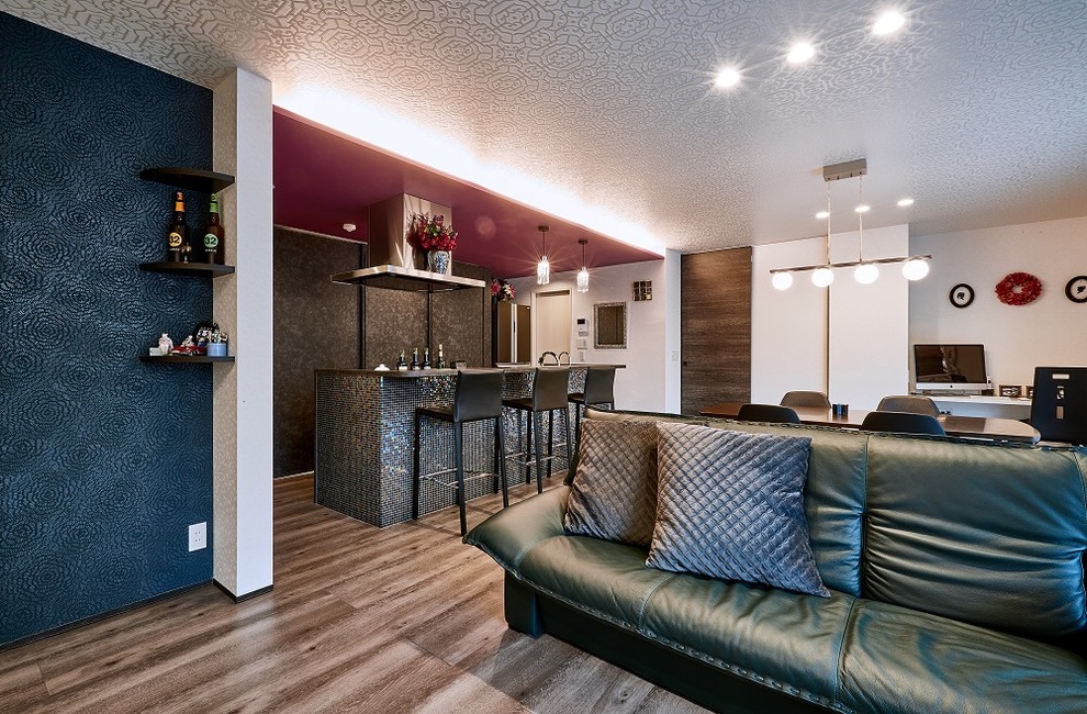 Bild på ett funkis allrum med öppen planlösning, med en hemmabar, vita väggar, plywoodgolv, en fristående TV och brunt golv