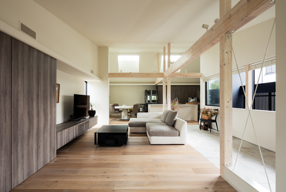 Foto de salón abierto de estilo zen con paredes blancas, suelo de madera clara, televisor independiente y suelo marrón