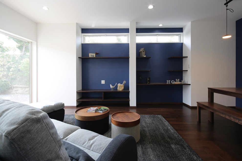 Modelo de salón actual con paredes blancas, televisor independiente, suelo marrón y suelo de madera oscura