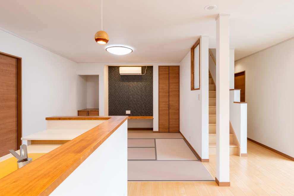 Mittelgroßes, Offenes Asiatisches Wohnzimmer ohne Kamin mit weißer Wandfarbe, Sperrholzboden, TV-Wand und beigem Boden in Sonstige
