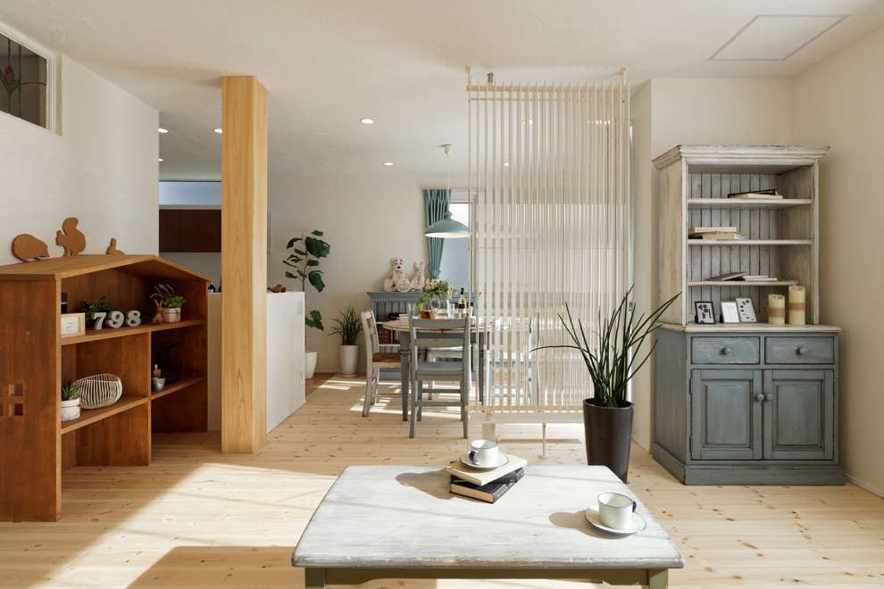 Ejemplo de salón abierto de estilo de casa de campo con paredes blancas, suelo de madera clara y suelo marrón