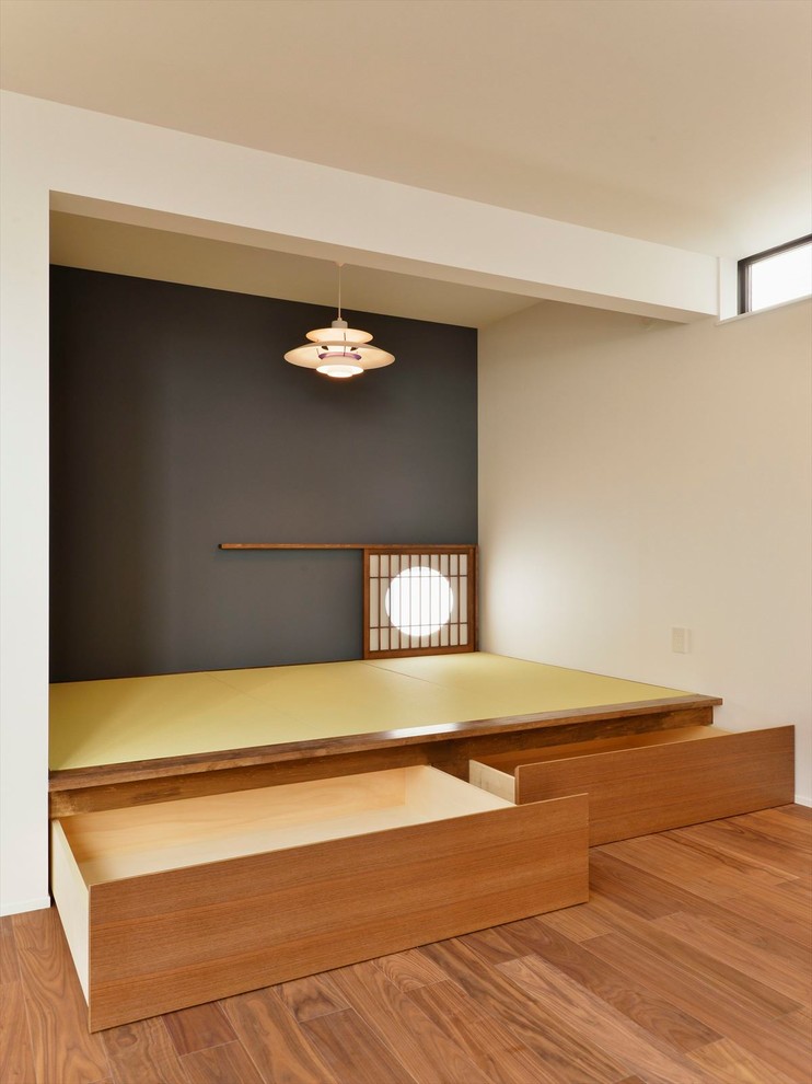 Idée de décoration pour un salon asiatique avec un mur bleu et un sol de tatami.