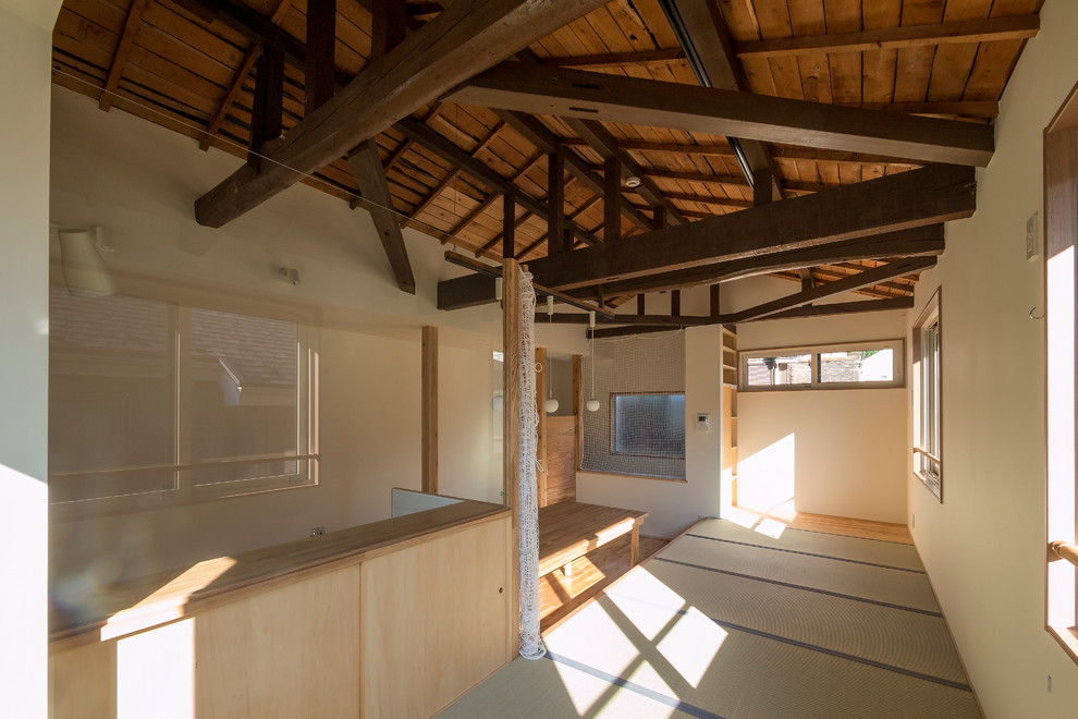 Réalisation d'un grand salon asiatique ouvert avec un mur blanc et un sol de tatami.