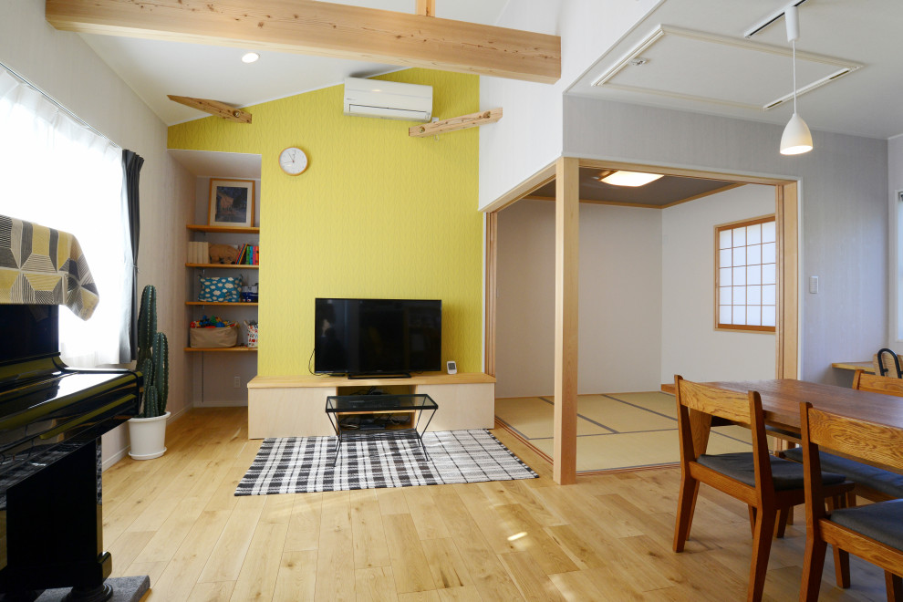 Foto di un soggiorno moderno di medie dimensioni e stile loft con pareti verdi, pavimento in legno massello medio e TV autoportante