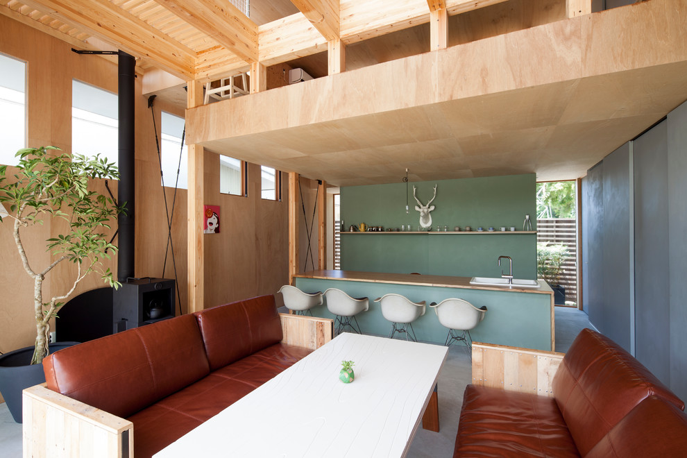 Diseño de salón abierto asiático pequeño con paredes blancas, suelo de cemento, estufa de leña y marco de chimenea de metal