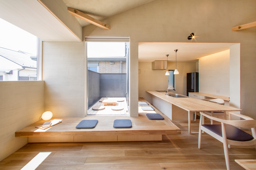 На фото: гостиная комната в восточном стиле с бежевыми стенами, светлым паркетным полом и коричневым полом