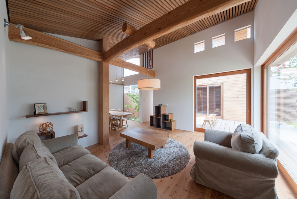 Imagen de salón abierto minimalista grande con paredes blancas y suelo de madera clara