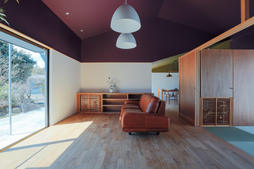 Modelo de salón de estilo zen con paredes blancas, suelo de madera clara y suelo marrón