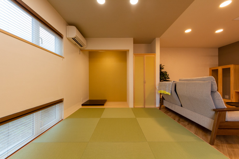 Cette photo montre un salon moderne ouvert avec un mur blanc, un sol de tatami, aucune cheminée et un sol vert.