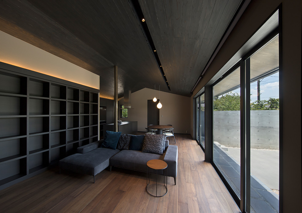 Diseño de salón abierto asiático pequeño con paredes marrones, suelo de contrachapado, televisor colgado en la pared y suelo marrón