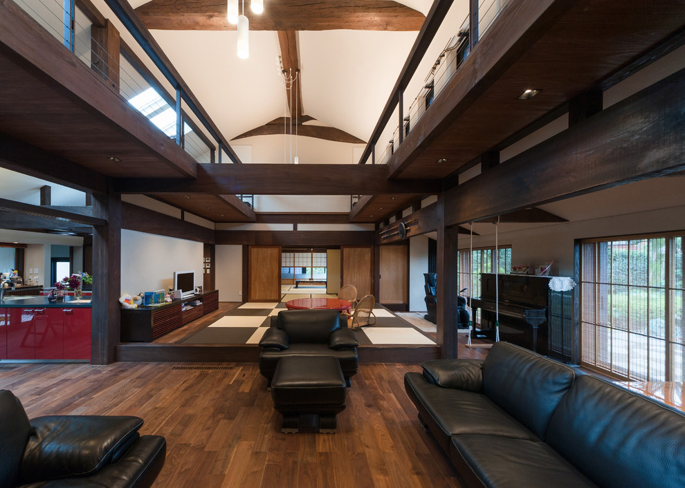 World-inspired open plan living room in Other with white walls and dark hardwood flooring.