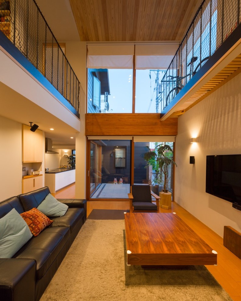 Idee per un soggiorno scandinavo di medie dimensioni e aperto con pareti bianche, pavimento in legno massello medio, TV a parete e pavimento marrone