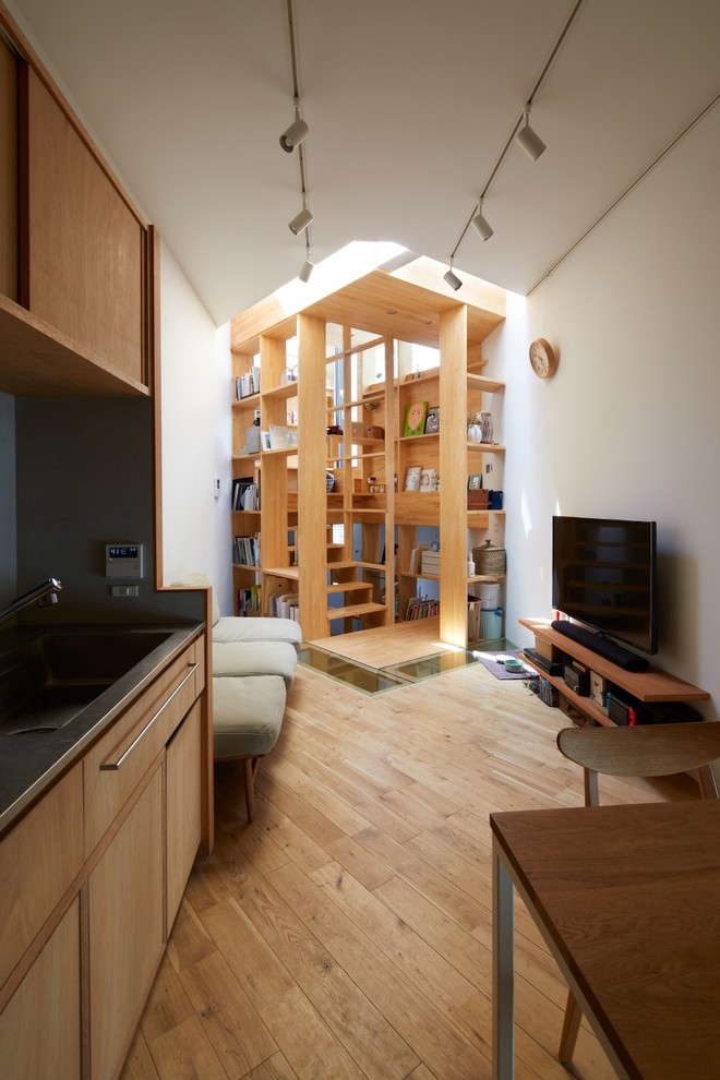 Источник вдохновения для домашнего уюта: маленькая открытая гостиная комната в современном стиле с белыми стенами, светлым паркетным полом, отдельно стоящим телевизором и коричневым полом для на участке и в саду