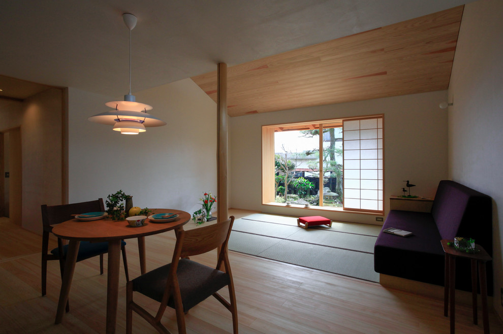 Diseño de salón abierto asiático con paredes blancas y suelo de madera clara