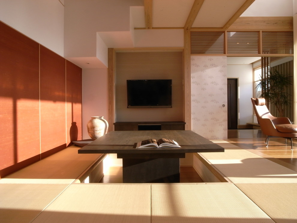 Ejemplo de salón asiático con paredes blancas, tatami, televisor colgado en la pared y suelo marrón