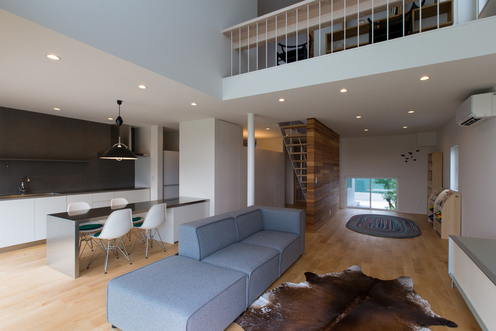 Immagine di un soggiorno minimal aperto con pareti bianche, parquet chiaro e pavimento beige