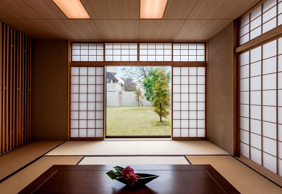 Aménagement d'un salon asiatique fermé avec un mur beige, un sol de tatami, aucune cheminée et aucun téléviseur.