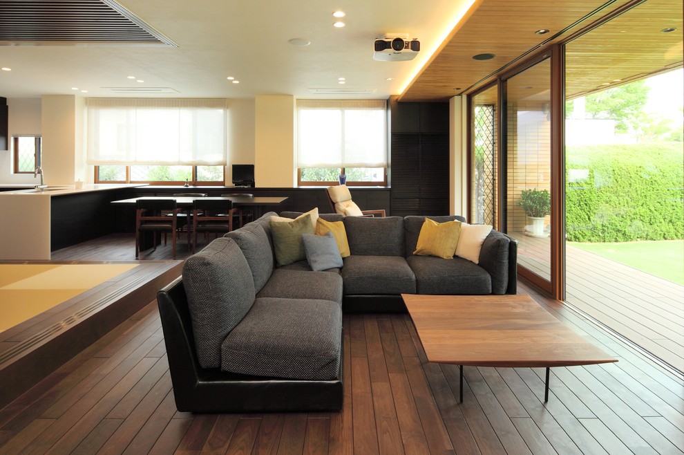 Exemple d'un salon moderne ouvert avec un sol en bois brun, un mur blanc, aucune cheminée et aucun téléviseur.