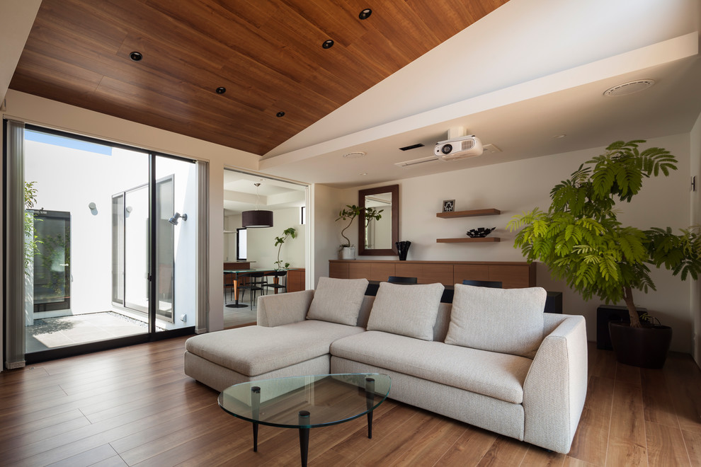 Inspiration for a contemporary enclosed dark wood floor and brown floor living room remodel in Other with white walls
