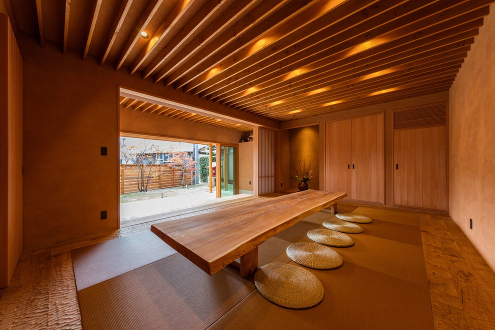 Cette image montre un salon asiatique avec une salle de réception, un mur marron et un sol de tatami.