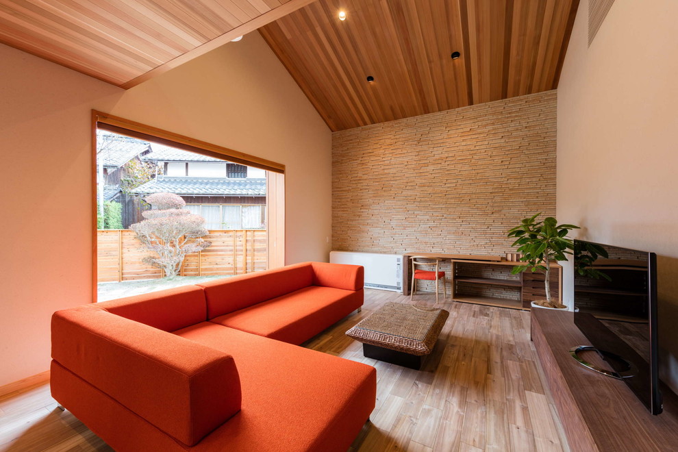 Ejemplo de salón de estilo zen con suelo de madera en tonos medios y televisor independiente