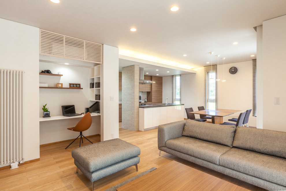 Immagine di un soggiorno moderno aperto con pareti bianche, parquet chiaro e pavimento marrone