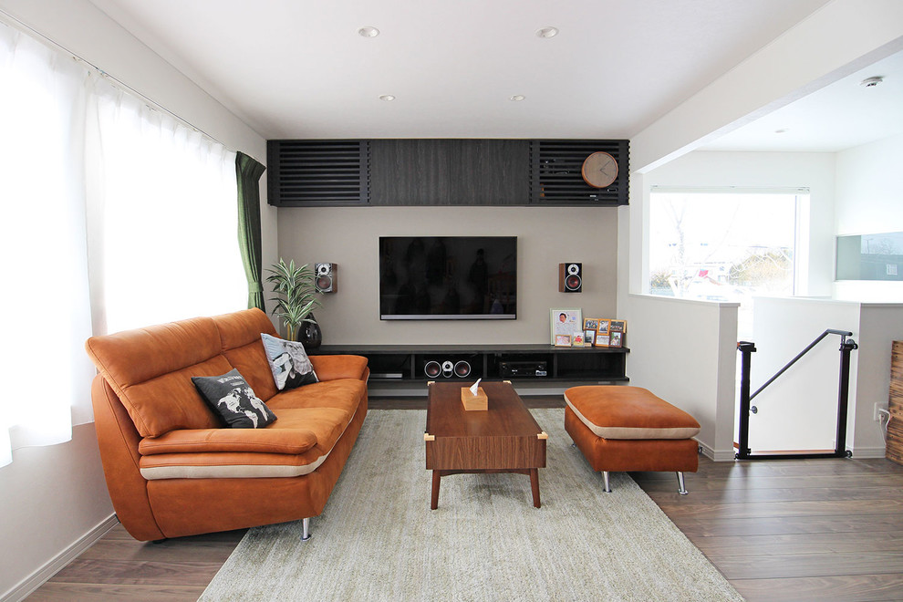 Foto de salón abierto minimalista sin chimenea con paredes blancas, televisor colgado en la pared y suelo marrón
