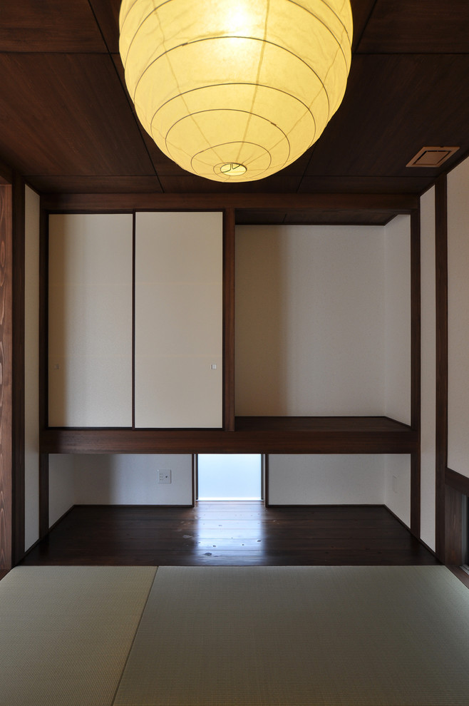 Réalisation d'un salon asiatique ouvert avec un mur blanc et un sol de tatami.