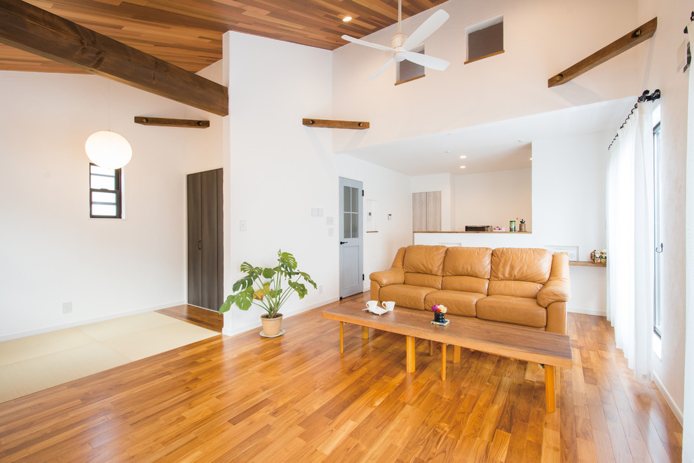 Exempel på ett modernt allrum med öppen planlösning, med vita väggar, mörkt trägolv, en fristående TV och brunt golv