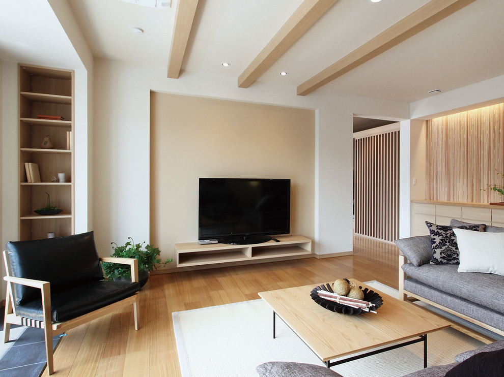 Living room in Yokohama with white walls, beige floors, plywood flooring and a freestanding tv.
