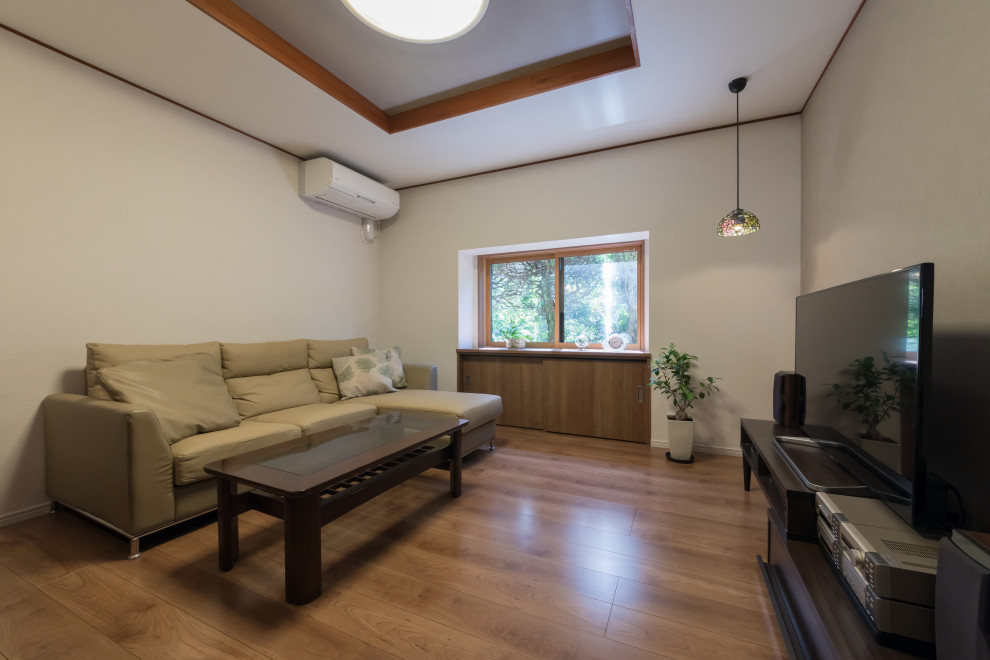 Idée de décoration pour un salon minimaliste de taille moyenne et fermé avec un mur beige, un sol en contreplaqué, un téléviseur indépendant, un sol beige et un plafond décaissé.