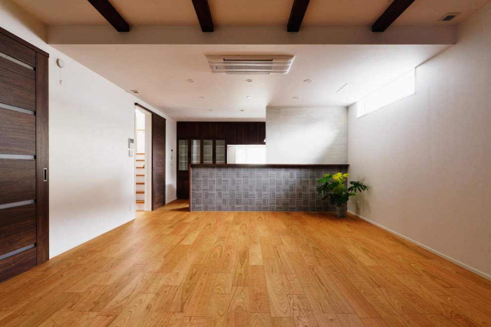Modelo de salón abierto minimalista con paredes blancas, suelo de contrachapado, vigas vistas y papel pintado