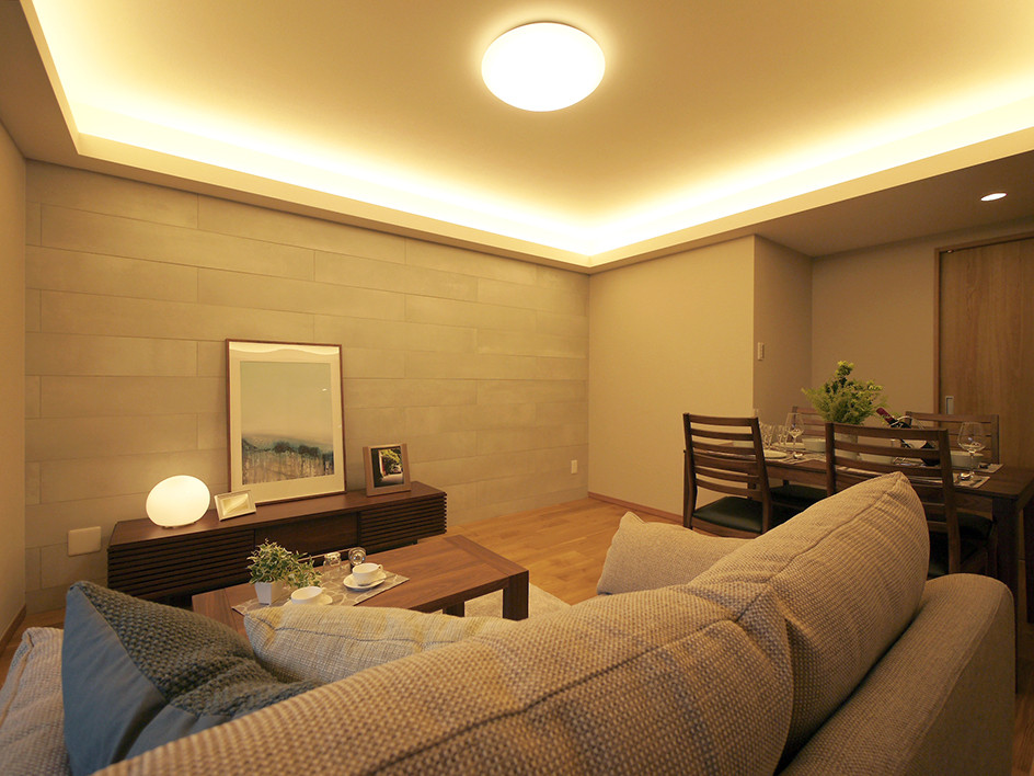 Modern open plan living room in Tokyo with grey walls, plywood flooring and brown floors.