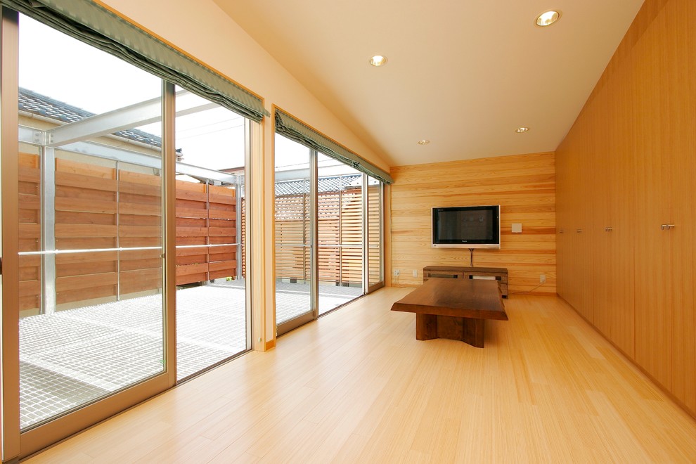 Bild på ett funkis allrum med öppen planlösning, med bruna väggar, bambugolv och beiget golv