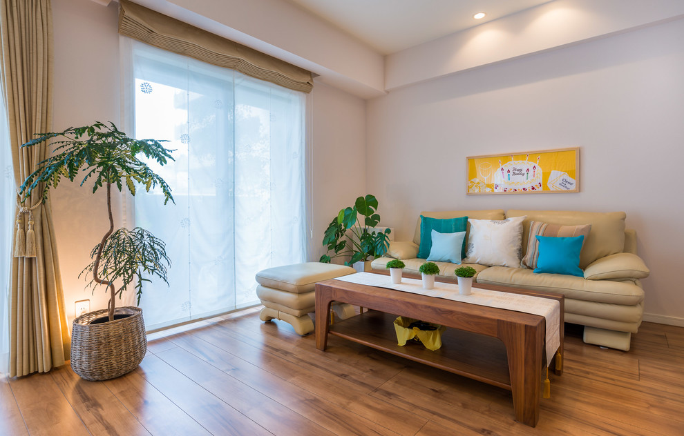 Esempio di un soggiorno boho chic di medie dimensioni e aperto con pareti bianche, pavimento in compensato, TV a parete e pavimento marrone