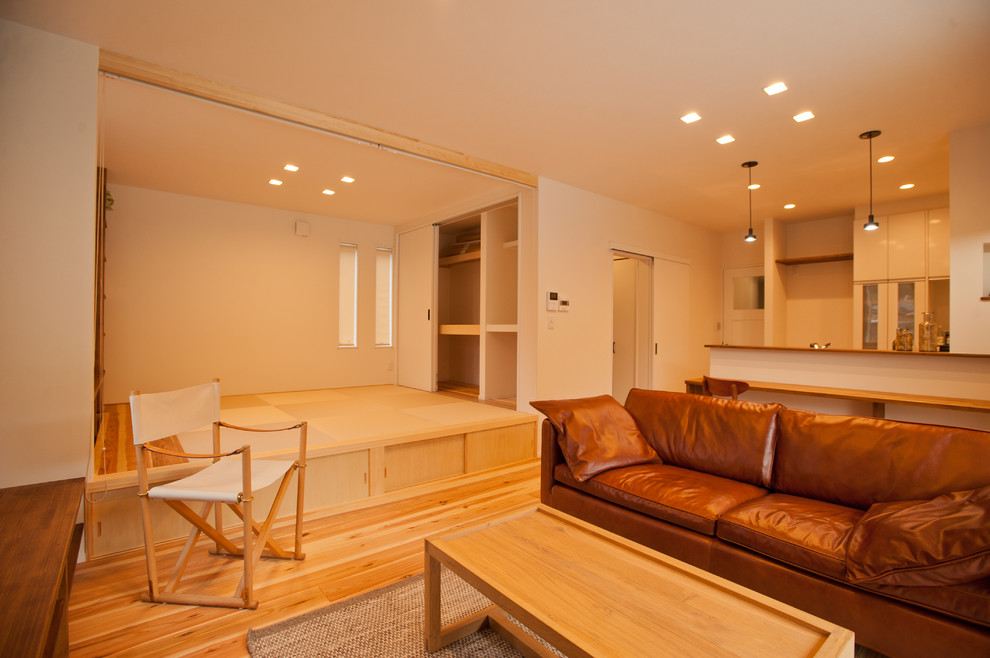 World-inspired living room in Other with white walls, medium hardwood flooring and brown floors.