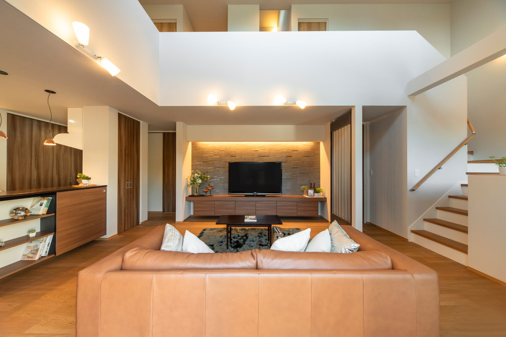 Imagen de salón abierto moderno grande con paredes blancas, suelo de madera en tonos medios y suelo marrón