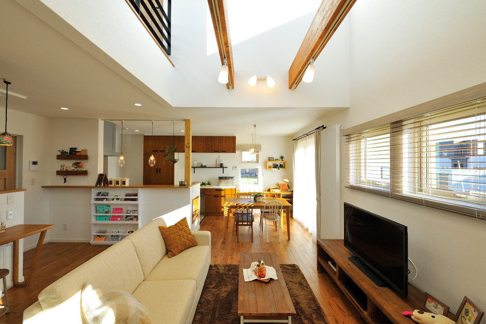 Offenes Asiatisches Wohnzimmer mit weißer Wandfarbe, braunem Holzboden, freistehendem TV und braunem Boden in Sapporo