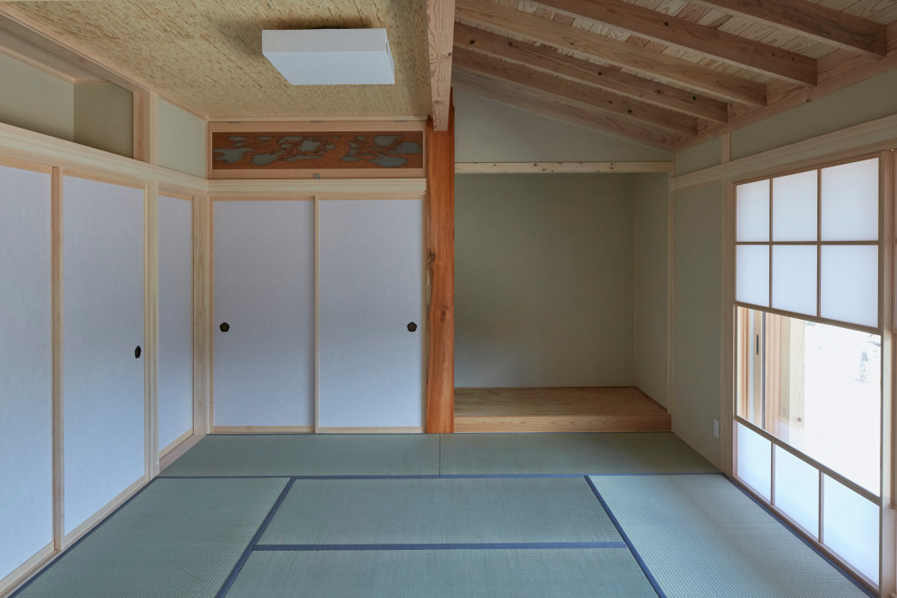 Aménagement d'un salon asiatique fermé avec un mur beige, un sol de tatami, aucune cheminée, aucun téléviseur et poutres apparentes.