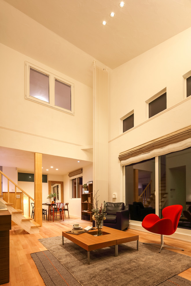 Ispirazione per un soggiorno etnico di medie dimensioni e aperto con pareti bianche, pavimento in legno massello medio e pavimento marrone
