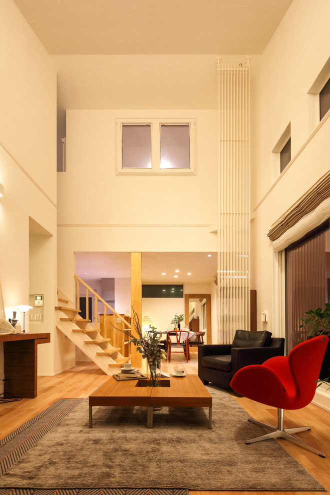 Immagine di un soggiorno etnico di medie dimensioni e aperto con pareti bianche, pavimento in legno massello medio, sala formale e pavimento beige