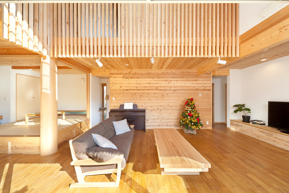 Asiatisches Wohnzimmer mit weißer Wandfarbe, freistehendem TV und braunem Boden in Sonstige