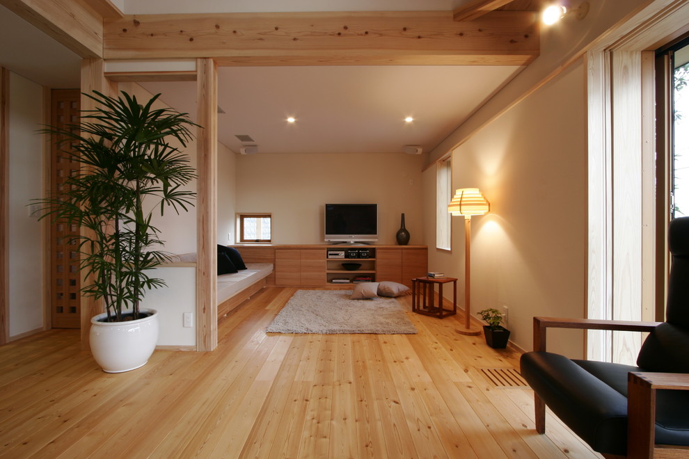 Réalisation d'un salon ouvert avec un mur beige, un sol en bois brun, aucune cheminée, un téléviseur indépendant et un sol beige.
