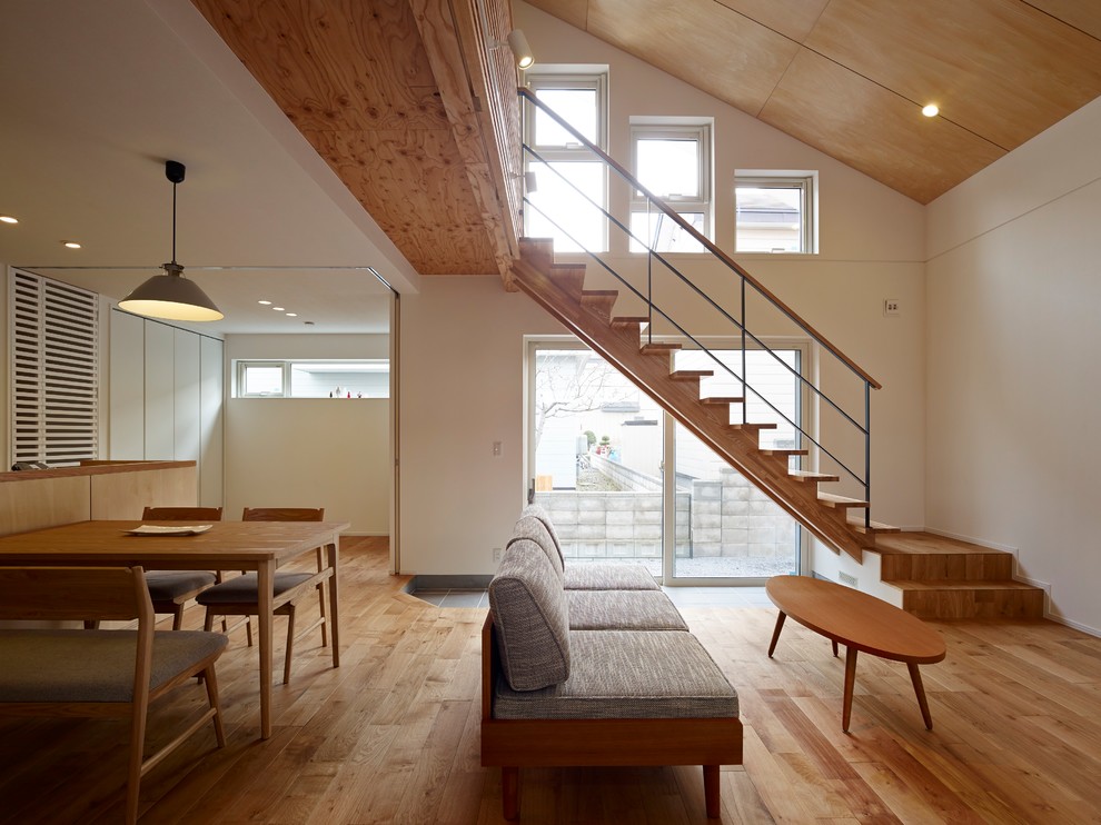 Стильный дизайн: гостиная комната среднего размера в восточном стиле с светлым паркетным полом, белыми стенами и коричневым полом - последний тренд