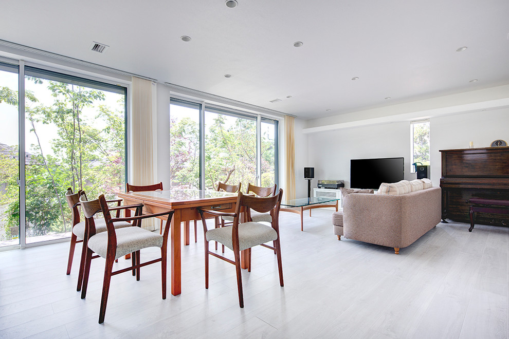 Idee per un soggiorno moderno con pareti bianche, pavimento in legno verniciato, TV autoportante e pavimento beige